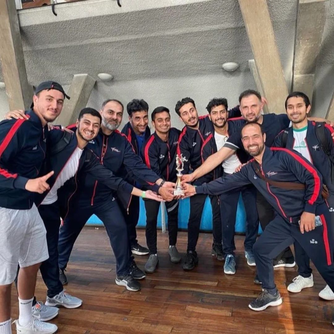 Coaching team celebrating with a competition trophy